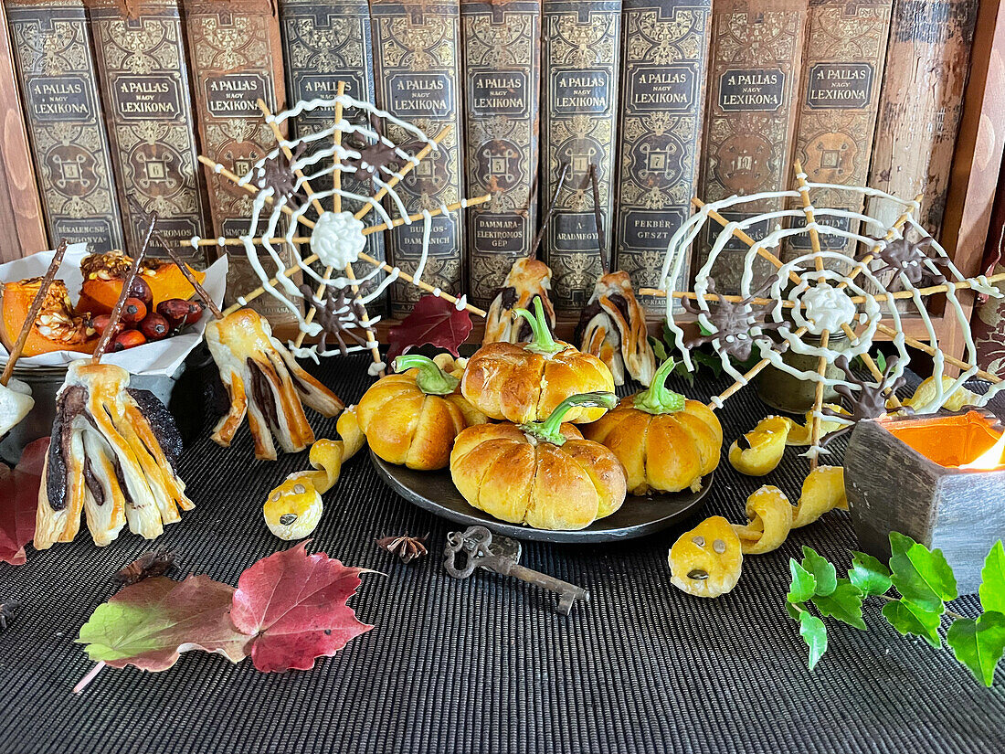 Gefüllte Mini-Kürbiskuchen, Salzstangen in Schlangenform, Schoko-Besen und Spinnennetze zu Halloween