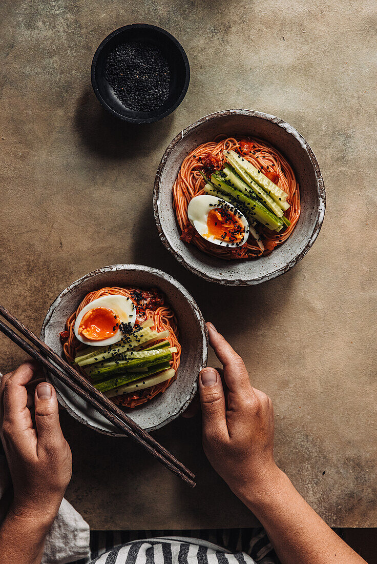 Cold Korean wheat noodles with soft-boiled egg in a spicy marinade made from gochujang paste