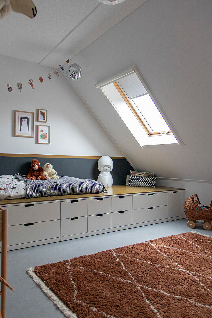 Minimalist children's room with sloped ceiling, integrated bed and storage space