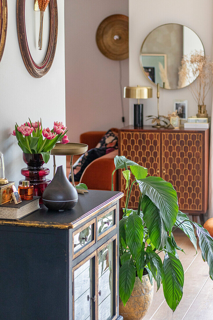 Console with tulips (Tulipa) and houseplant in modern hallway