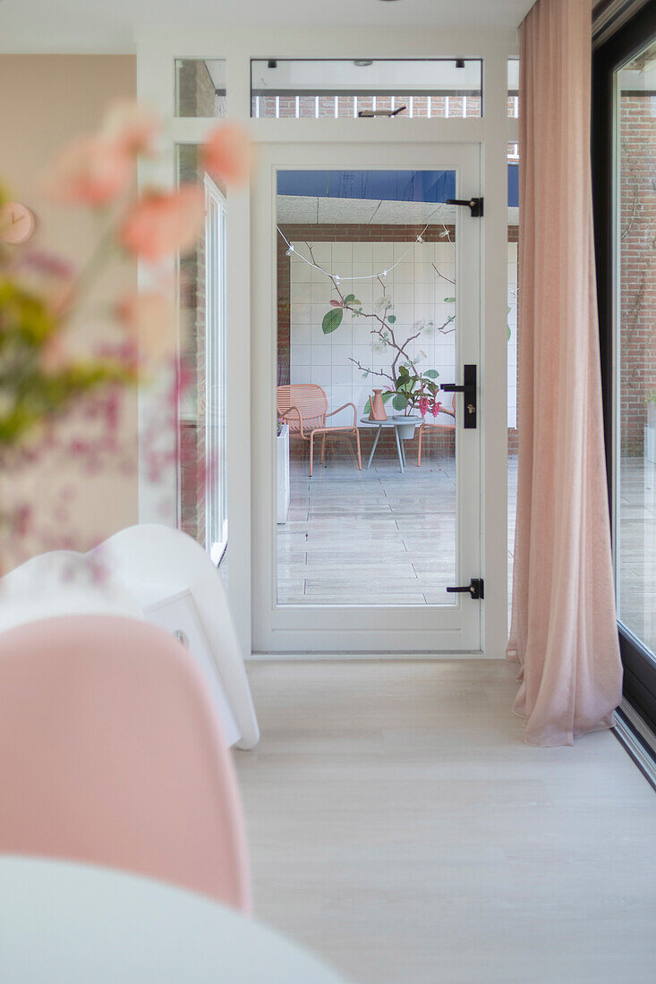 Sun-drenched living room with a view of a glass patio door, pink accents