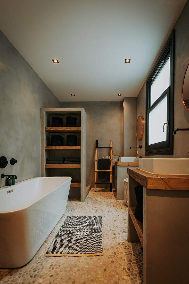 Bathroom with grey walls, free-standing bathtub and wooden elements