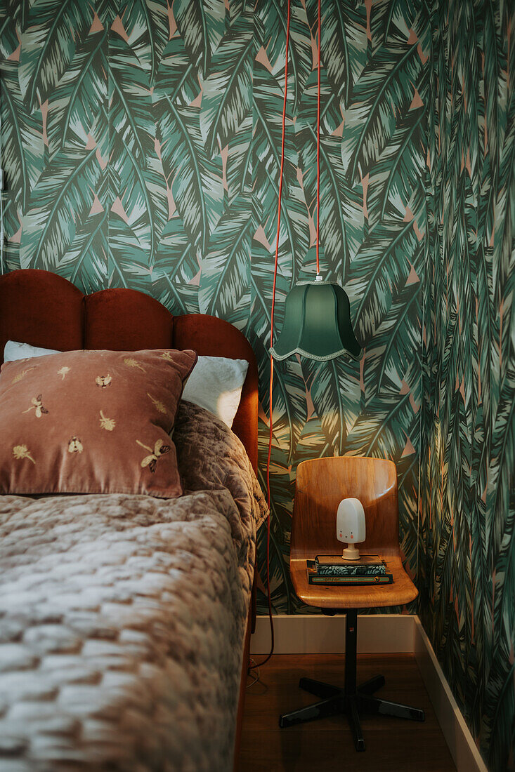 Bedroom with palm leaf wallpaper and retro floor lamp