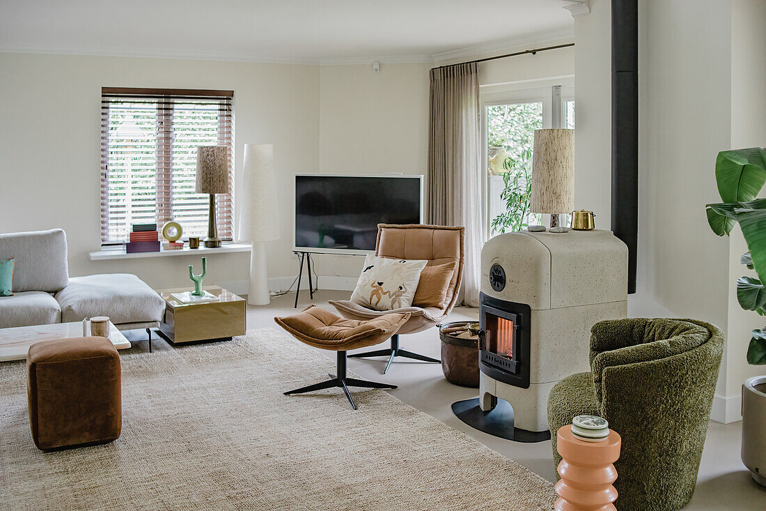 Modern living room with beige carpet, green armchair and fireplace