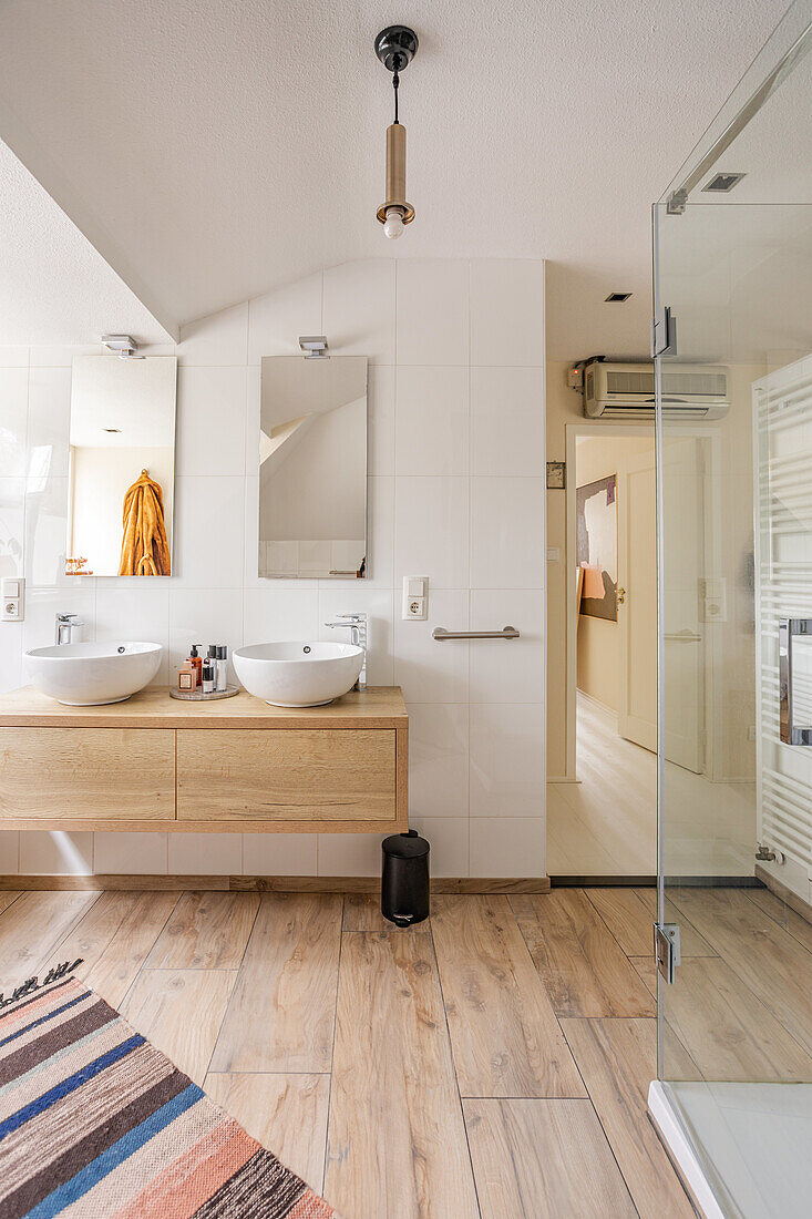 Modern bathroom with double washbasins and wooden vanity unit