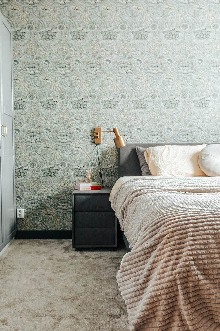 Bedroom with patterned wallpaper and cozy bed in light colors