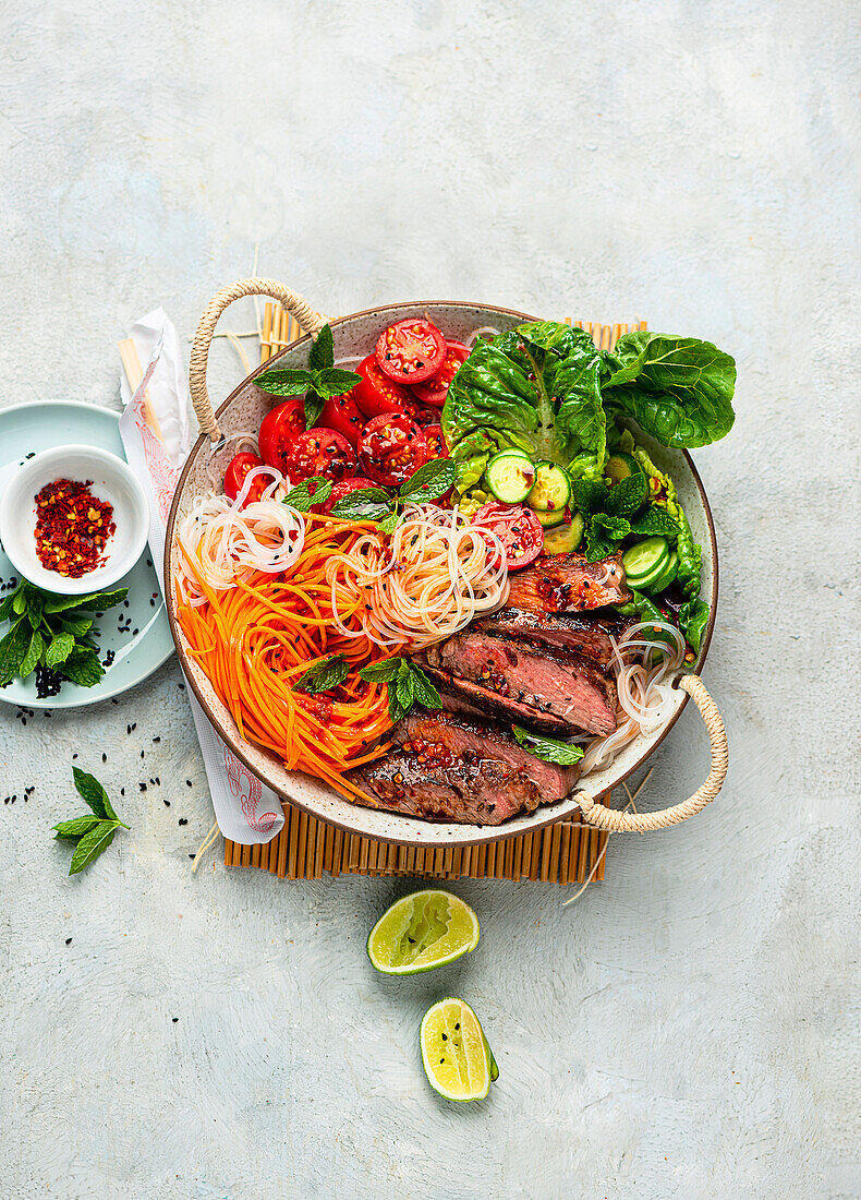 Rice noodle and vegetable bowl with grilled steak