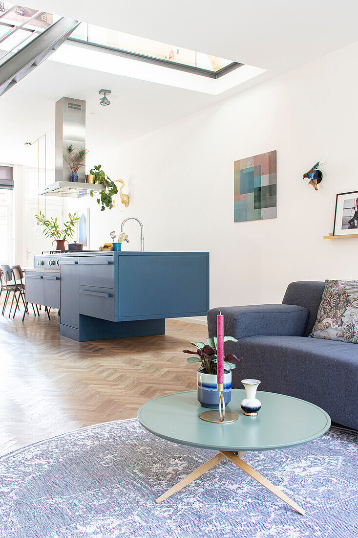 Open-plan living room with blue kitchen island and modern decor