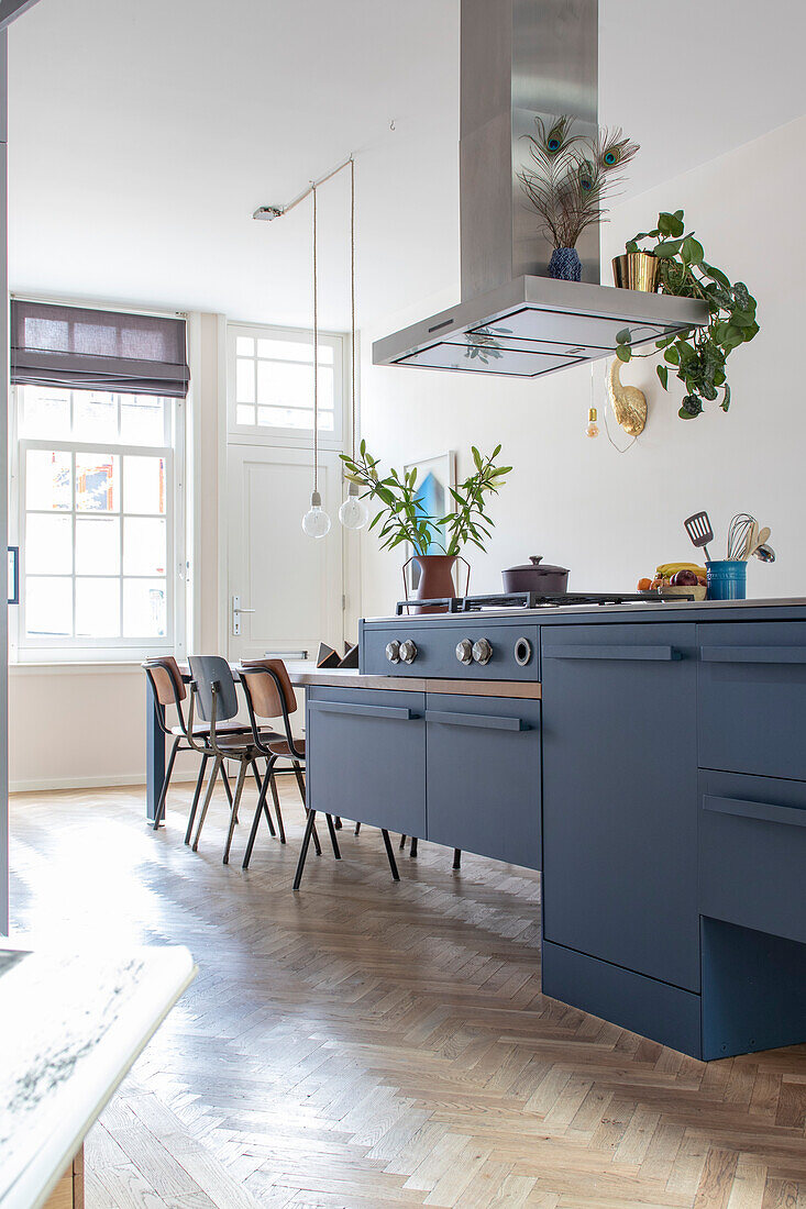 Open-plan kitchen with blue cabinets and parquet flooring