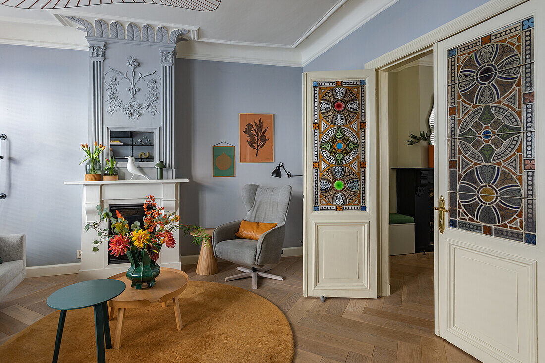 Wohnzimmer mit kunstvollen Glasfenstertüren und weißem Kamin