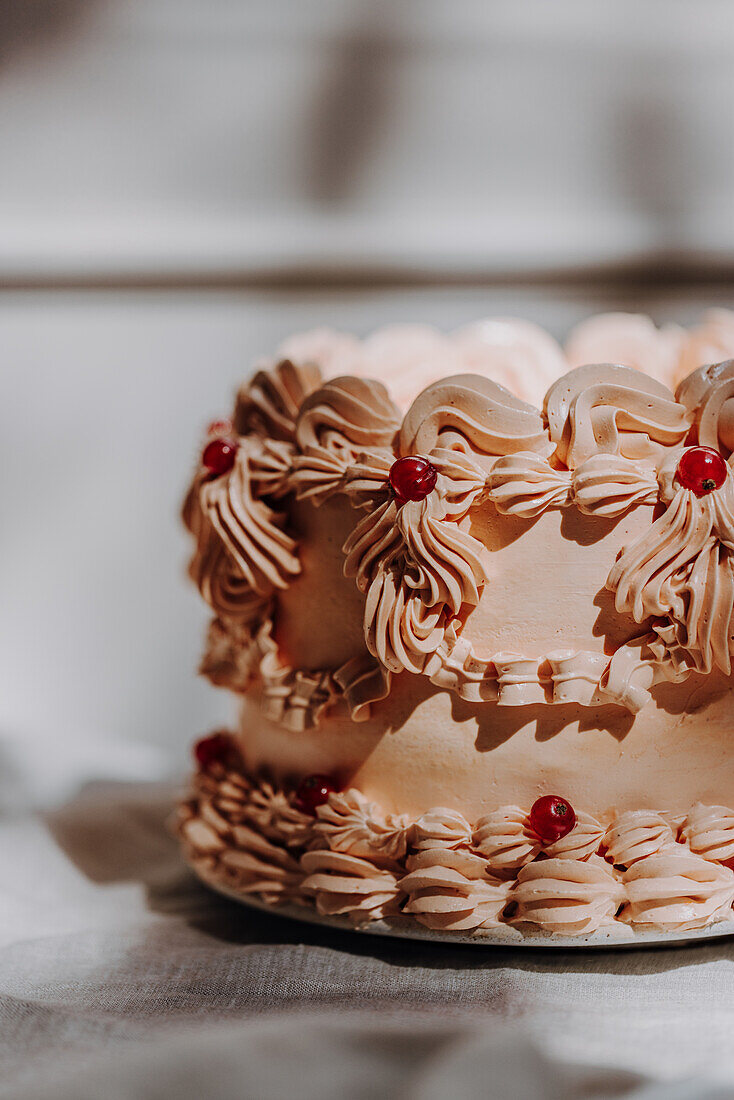 Vintage cake trend with piped buttercream ruffles and redcurrant decorations