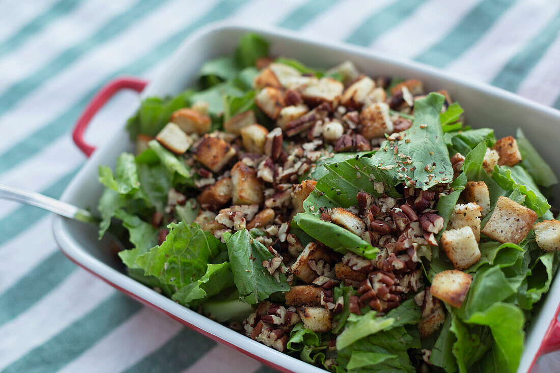 Still life close up healthy, fresh salad with walnuts and croutons\n