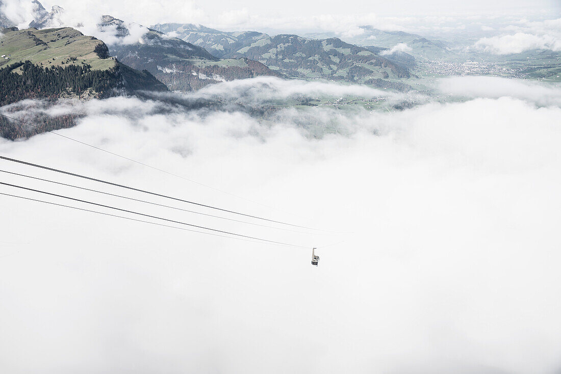 Ski gondola above clouds, Hoher Kasten, St. Gallen, Switzerland\n