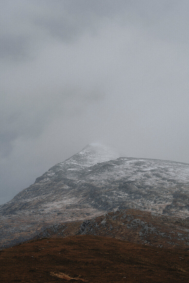 Wolken über einem schneebedeckten Berg, Assynt, Sutherland, Schottland