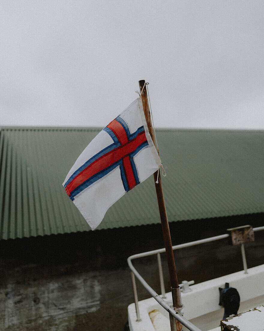 Flag of the Faroe Islands on boat, Bour, Vagar, Faroe Islands\n