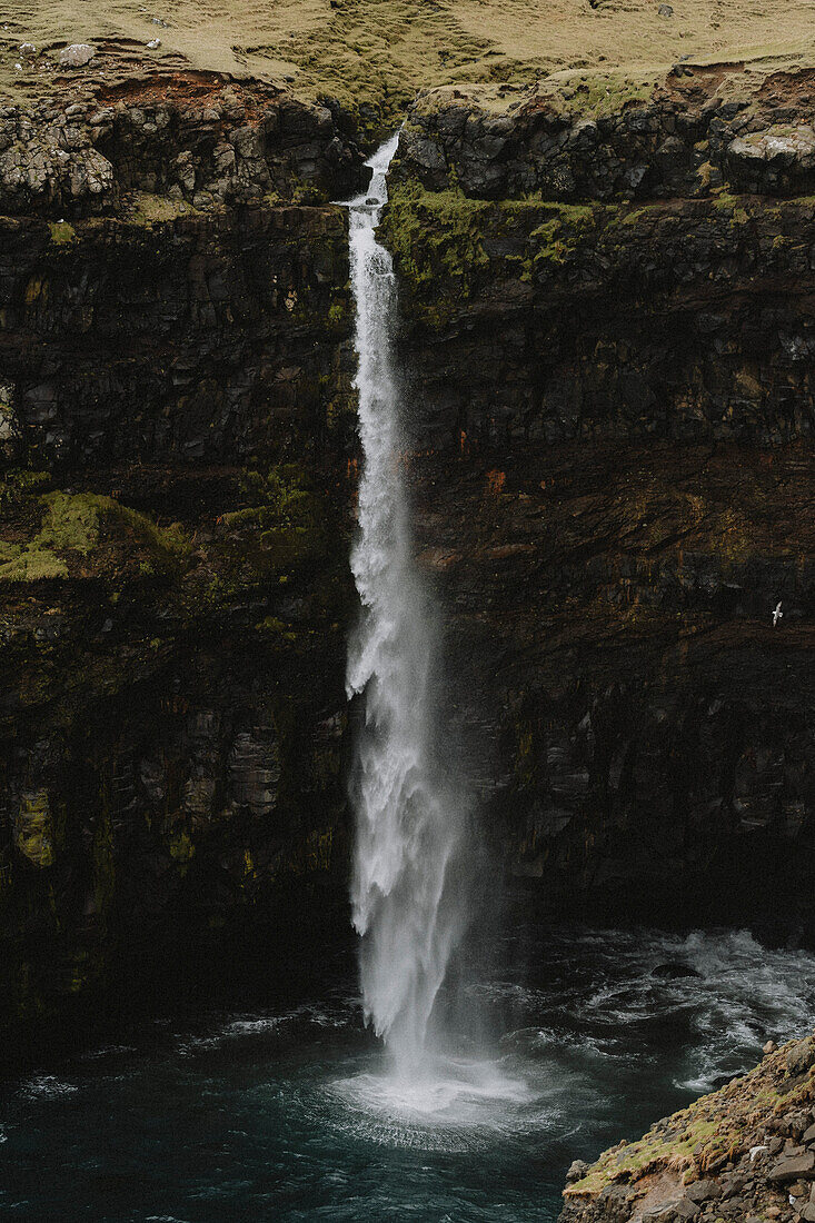 Hoher Wasserfall über moosbewachsener Klippe, Gasadalur, Vagar, Färöer Inseln