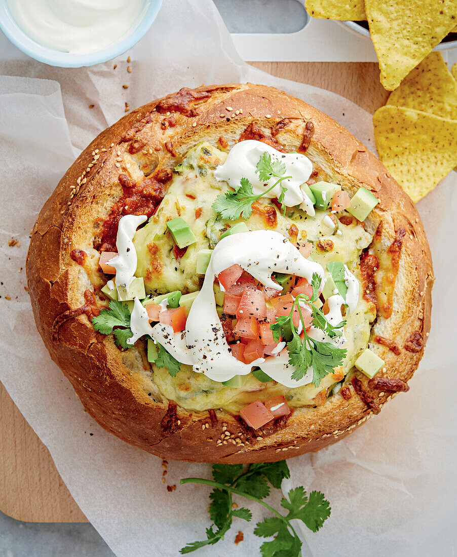 Chili in bread bowl with corn and cheese topping