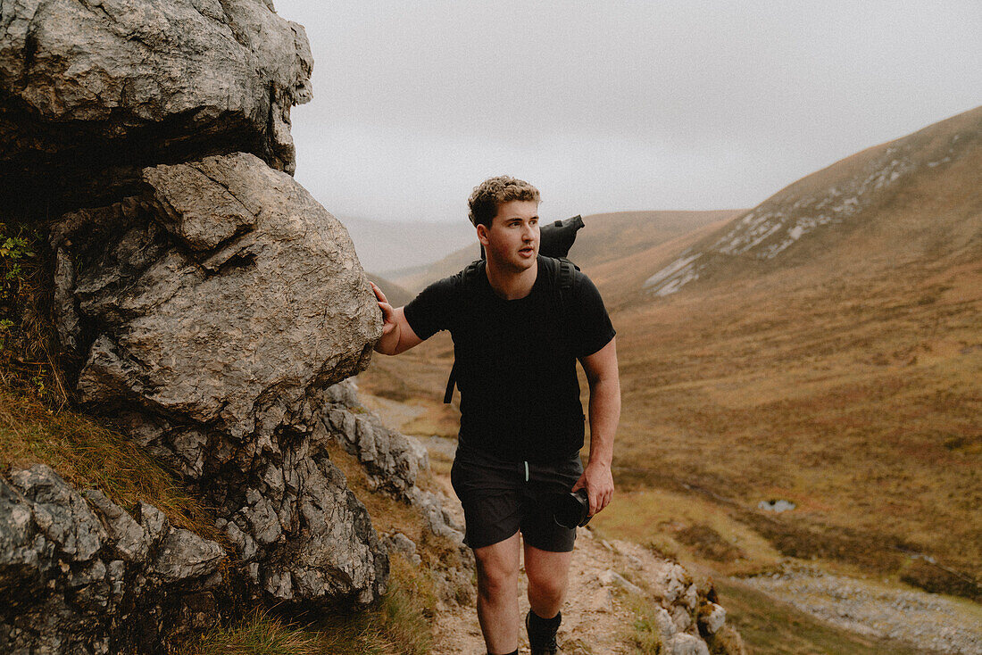 Man hiking in rugged mountains, Assynt, Sutherland, Scotland\n