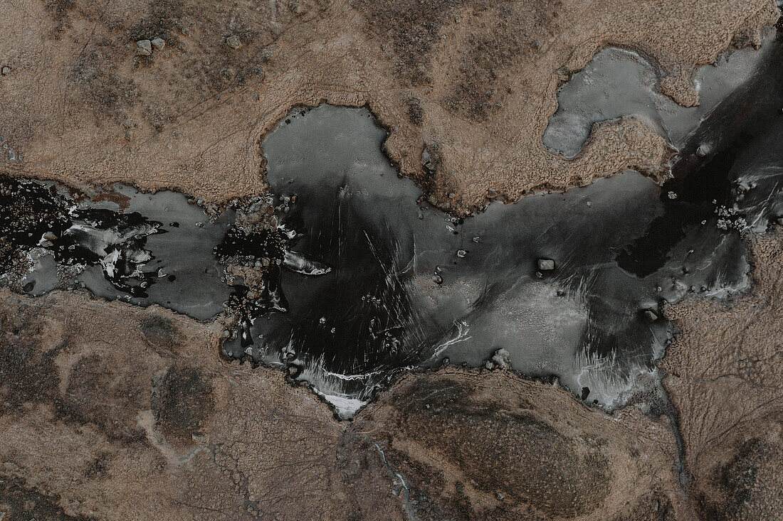 Aerial view from above icy river, Glencoe, Scottish Highlands, Scotland\n