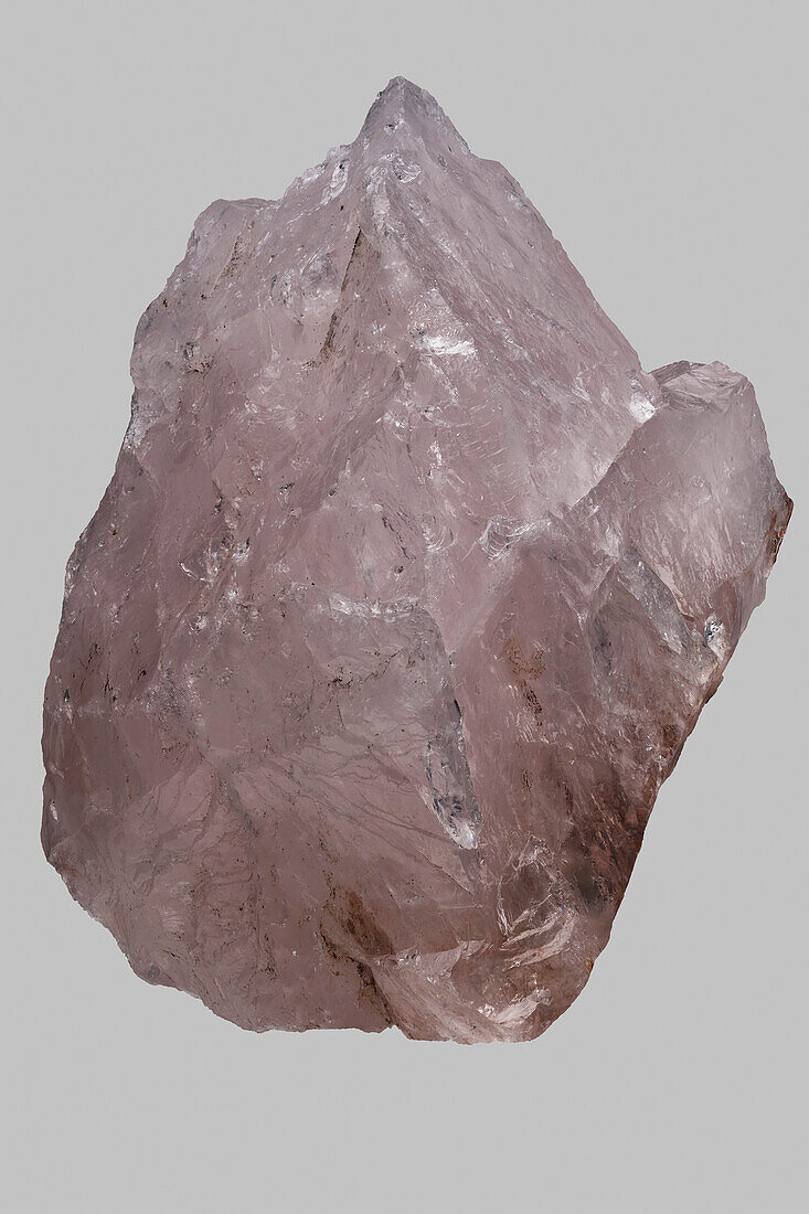 Close up pink Madagascan rose quartz on gray background\n