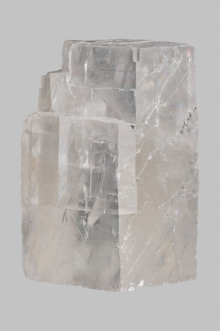 Close up translucent Icelandic calcite stone on gray background\n