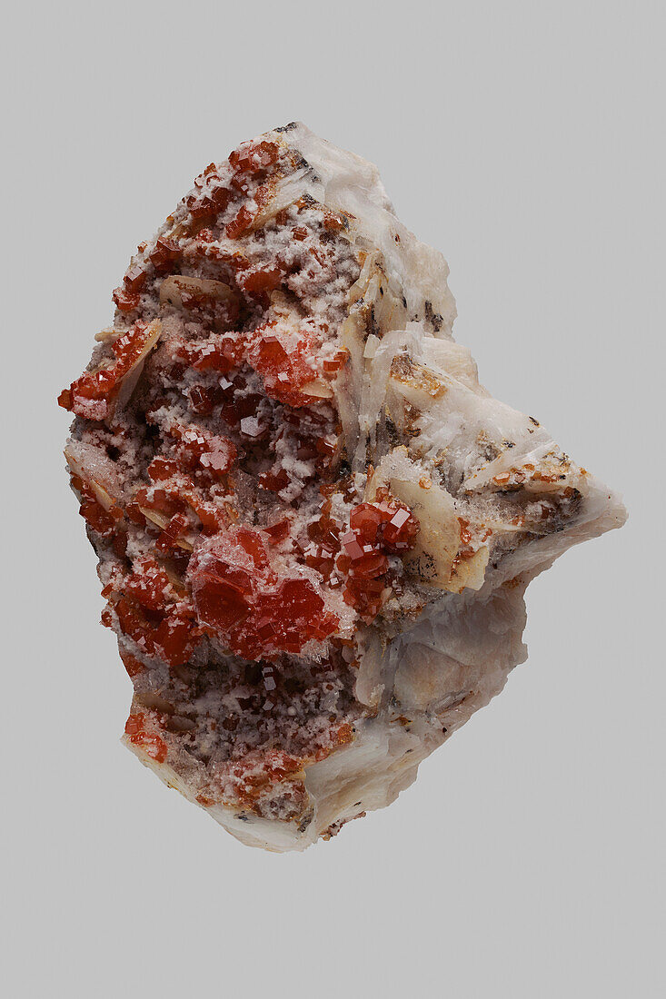 Close up detail textured red Moroccan vanadinite stone on gray background\n