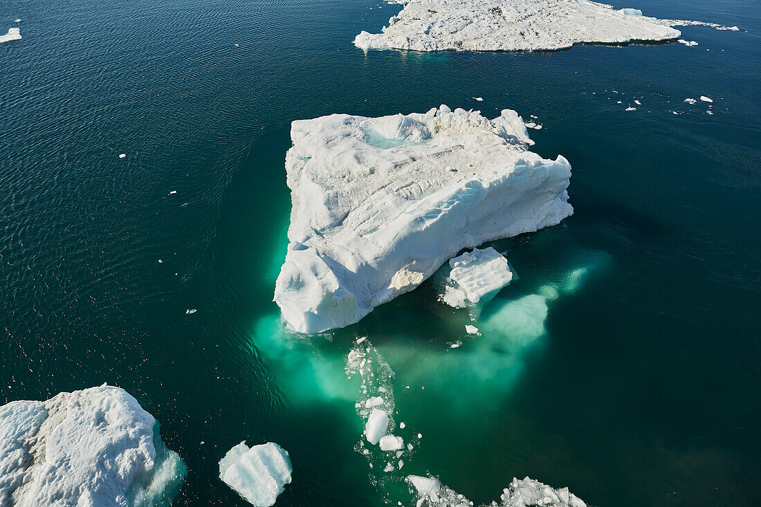 Schmelzender Eisberg auf sonniger Meeresoberfläche, Antarktische Halbinsel, Weddellmeer, Antarktis