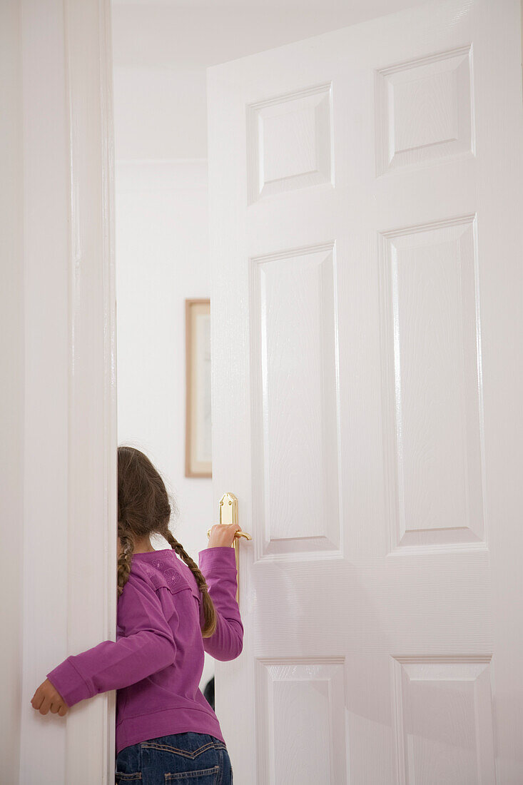 Rückenansicht eines Mädchens beim Öffnen der Tür