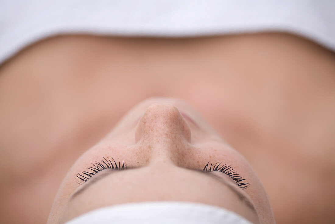Close up of young woman lying on back and relaxing after beauty treatment\n