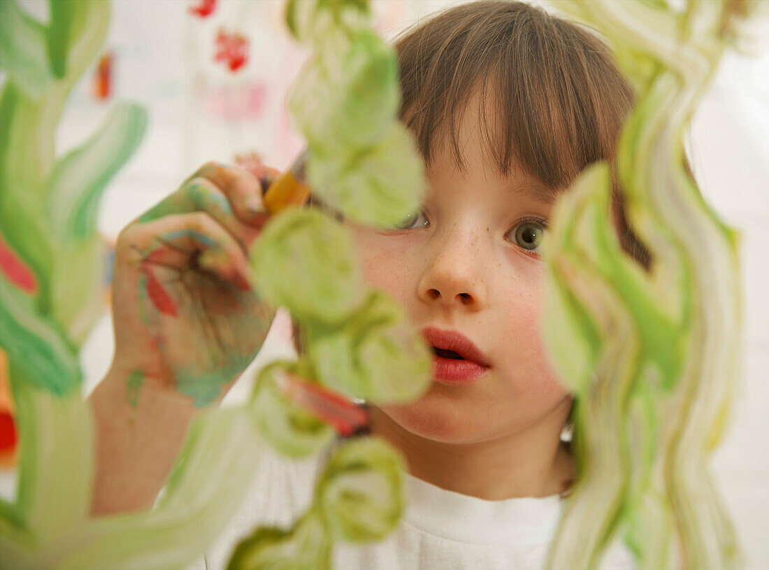 Nahaufnahme eines jungen Mädchens beim Malen auf Glas