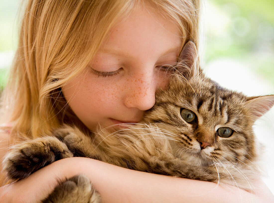 Nahaufnahme eines jungen Mädchens, das ein Kätzchen umarmt