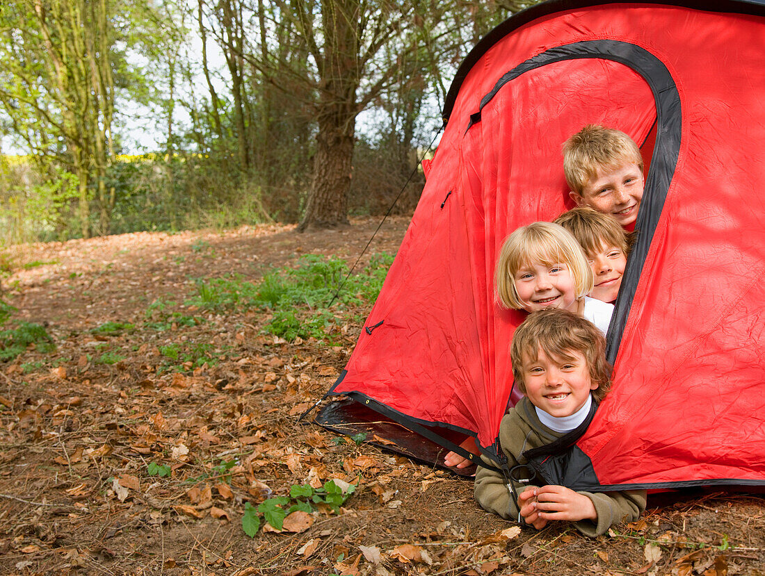Portrait of children coming out of tent opening\n