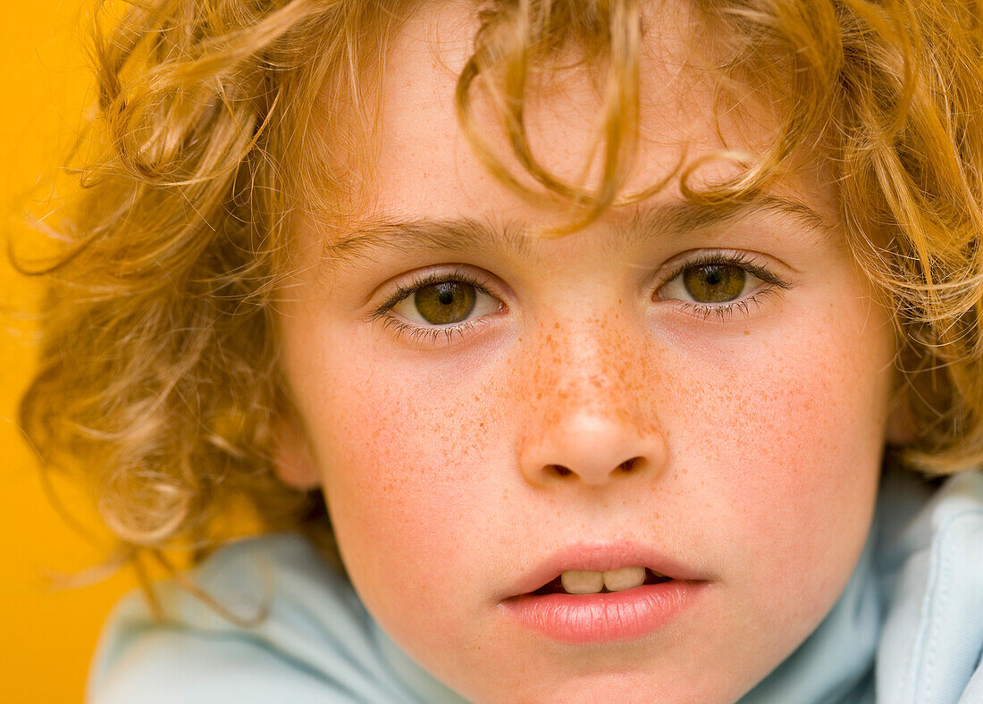 Close up of a young boy with curly hair\n