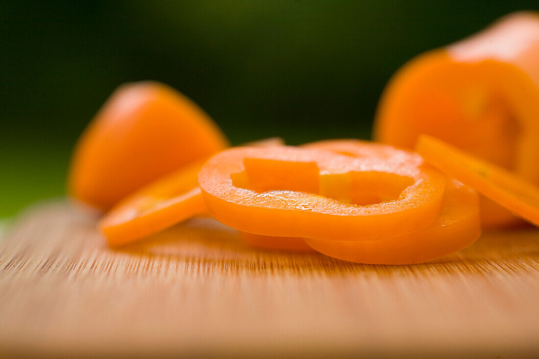 Geschnittene orangefarbene Paprikaschoten auf einem Schneidebrett