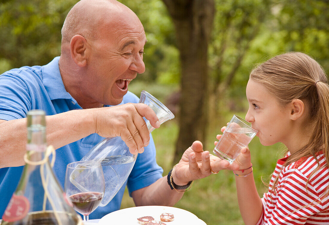 Großvater und Enkelin trinken Wasser