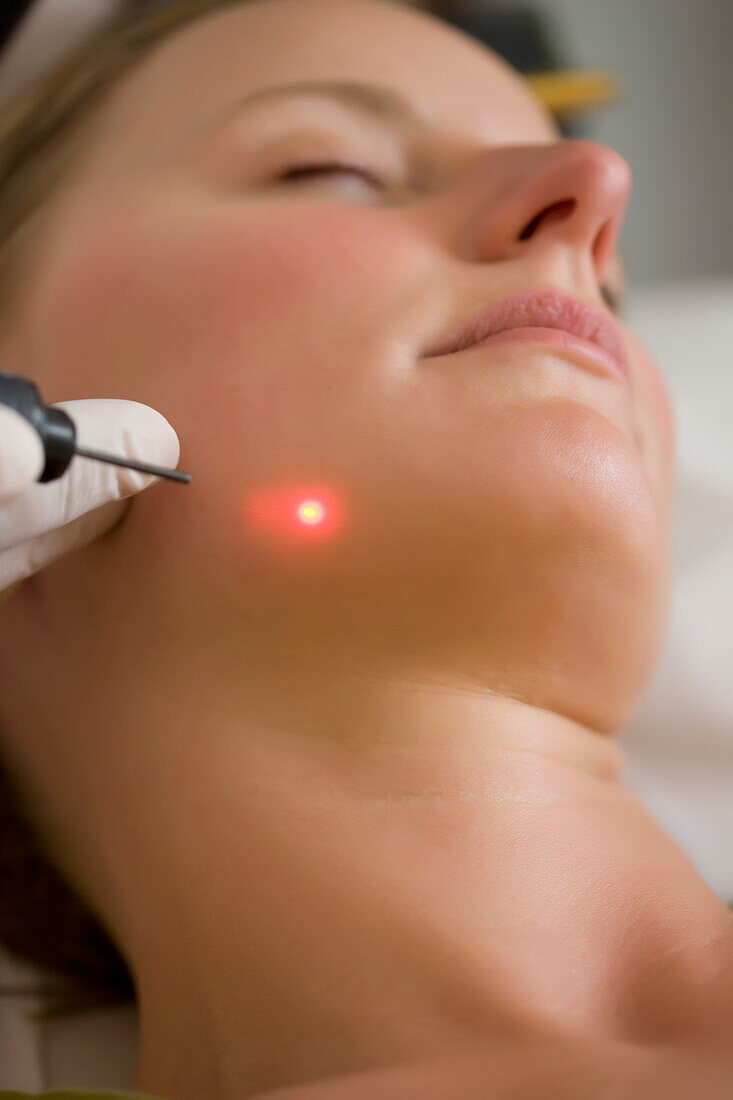 Close up of a woman receiving a laser treatment on her face\n