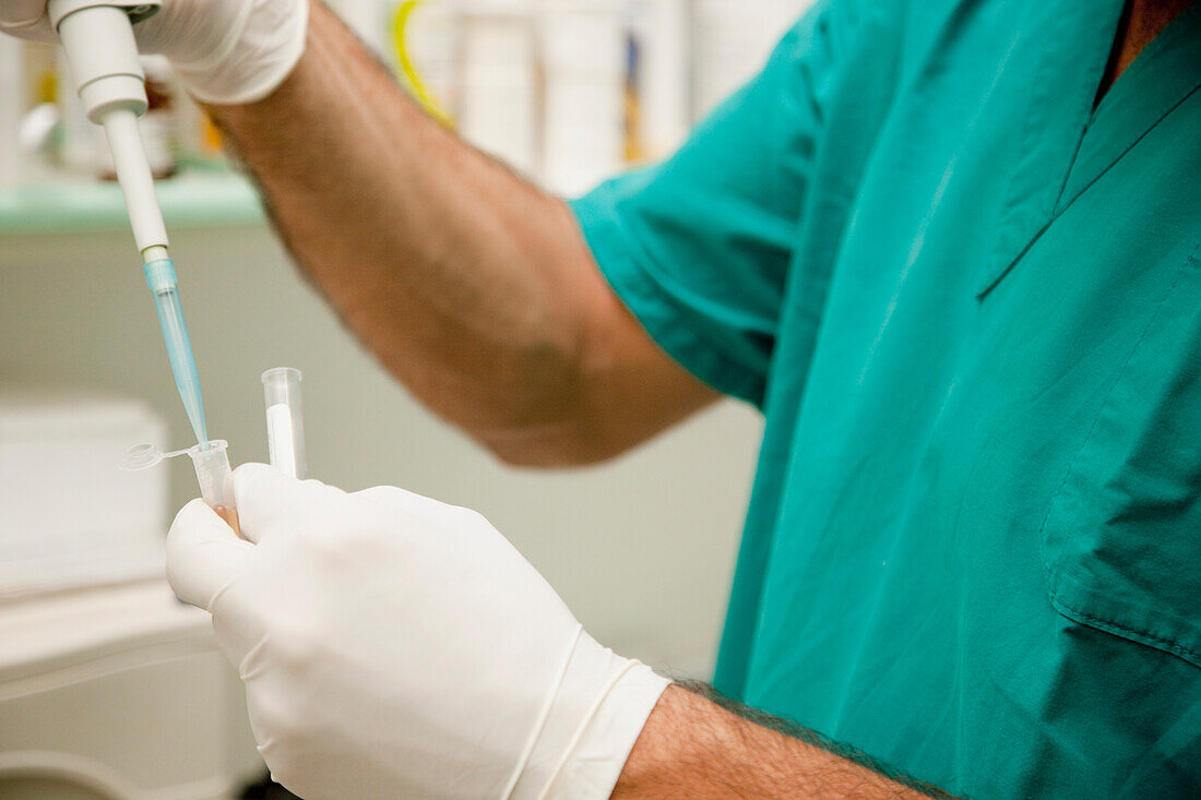 Healthcare professional holding a medical dropper\n