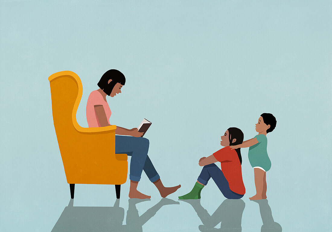 Mother in armchair reading book to daughter and son at home\n