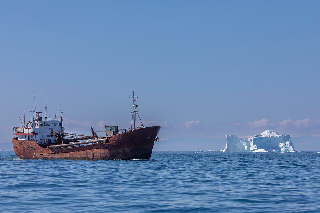 Frachter nahe Eisberg aus dem nahegelegenen Ilulissat-Eisfjord schwimmt bei Ilulissat, Westgrönland, Polargebiete