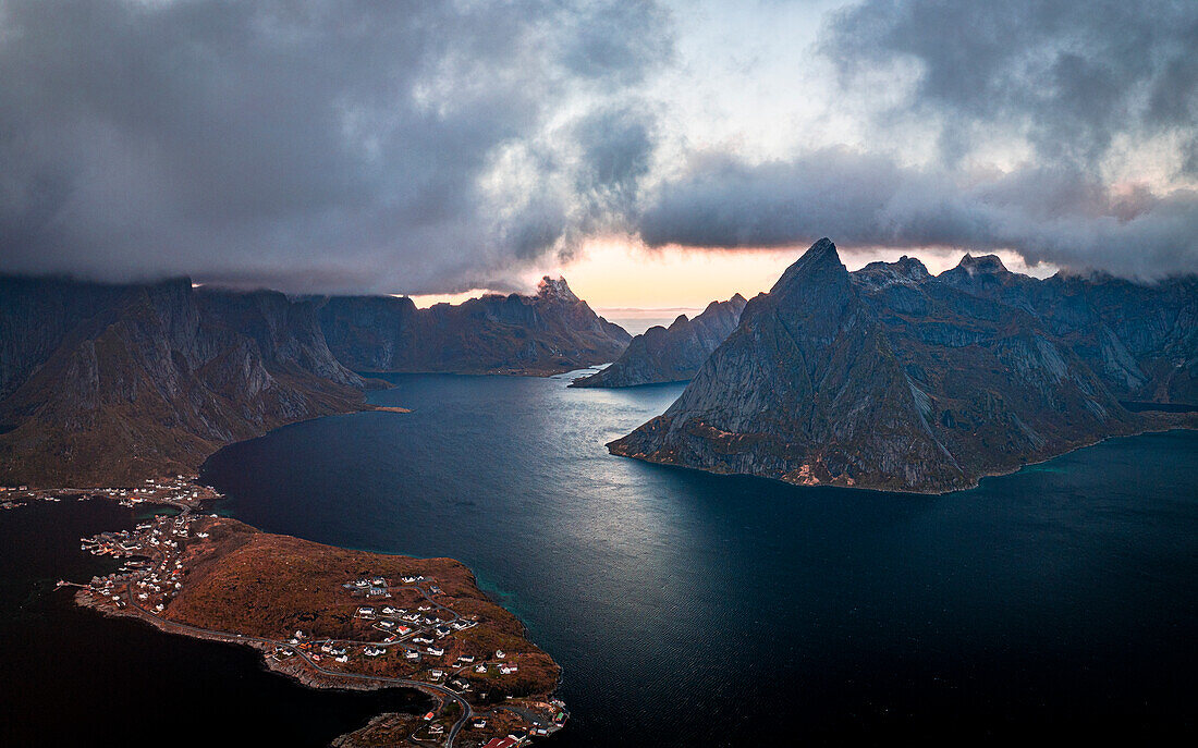 Sturmwolken bei Sonnenuntergang über majestätischen Bergen entlang eines Fjords, Luftaufnahme, Reine Bucht, Lofoten Inseln, Nordland, Norwegen, Skandinavien, Europa