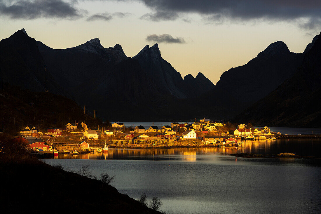 Silhouetten von Bergen, die das Märchendorf am Fjord in der Morgendämmerung einrahmen, Reine Bay, Lofoten Inseln, Nordland, Norwegen, Skandinavien, Europa