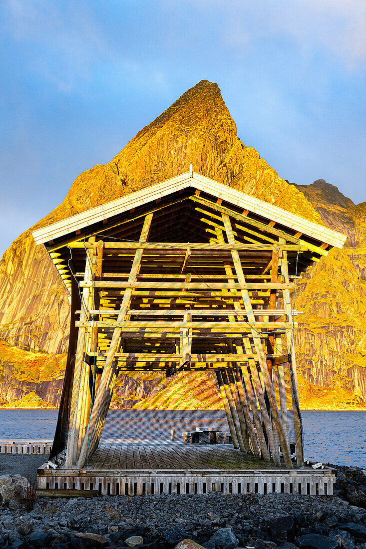 Fischerhütten mit Blick auf das kalte Meer und den Olstind im Hintergrund, Sakrisoy, Reine, Lofoten, Nordland, Norwegen, Skandinavien, Europa