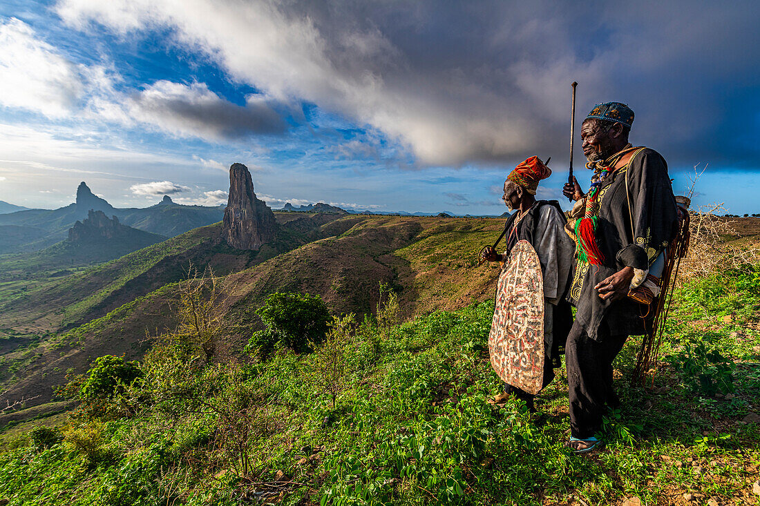 Kapsiki tribal men in front of the lunar landscape of Rhumsiki peak, Rhumsiki, Mandara mountains, Far North province, Cameroon, Africa\n