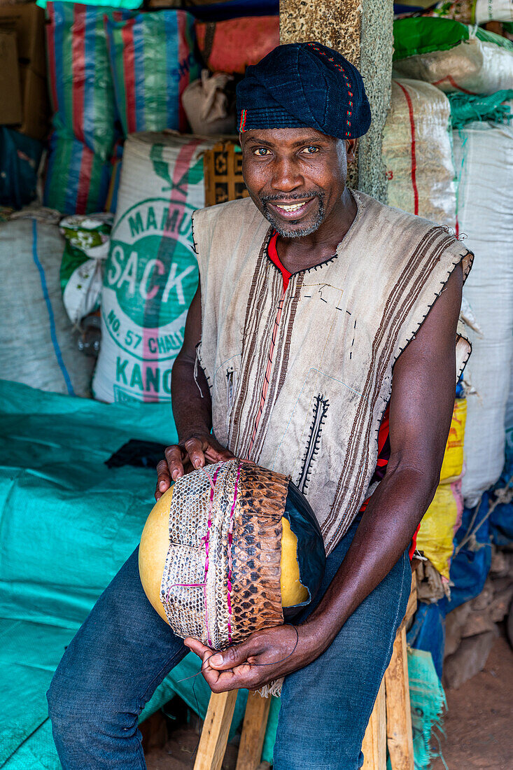 Man creating a snake hat, traditional medicine market, Garoua, Northern Cameroon, Africa\n
