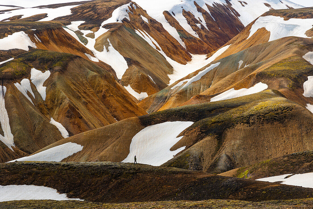 Eine Person genießt die schöne Landschaft im Landmannalaugar-Gebirge an einem Sommertag, Island, Polarregionen