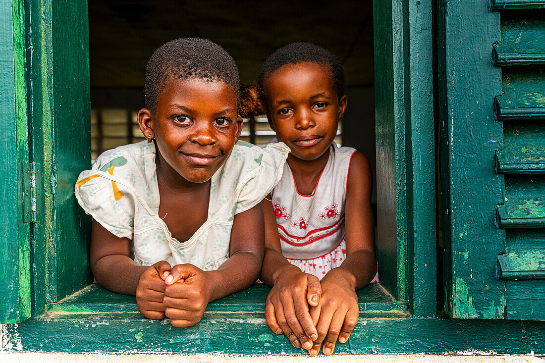 Junge Schulkinder schauen aus einem Fenster, Ciudad de la Paz, Rio Muni, Äquatorialguinea, Afrika