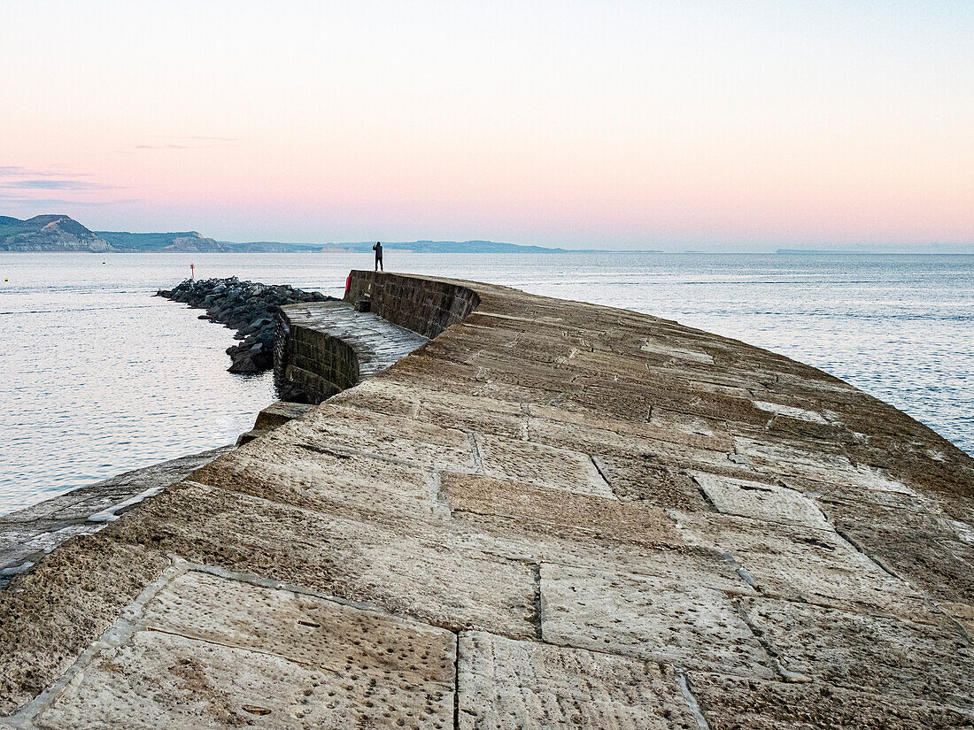 Taking a photograph at the end of The Cobb at sunset, Lyme Regis, Dorset, England, United Kingdom, Europe\n