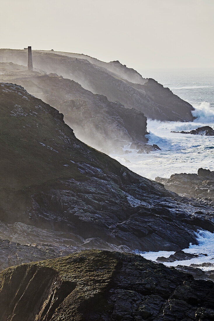 Atlantikklippen, die bei stürmischem Winterwetter von der Brandung umspült werden, bei Pendeen, mit den Ruinen alter Zinnminen, Teil des UNESCO-Welterbes Cornwall und West Devon Mining Landscape, bei St. Just, Cornwall, England, Vereinigtes Königreich, Europa