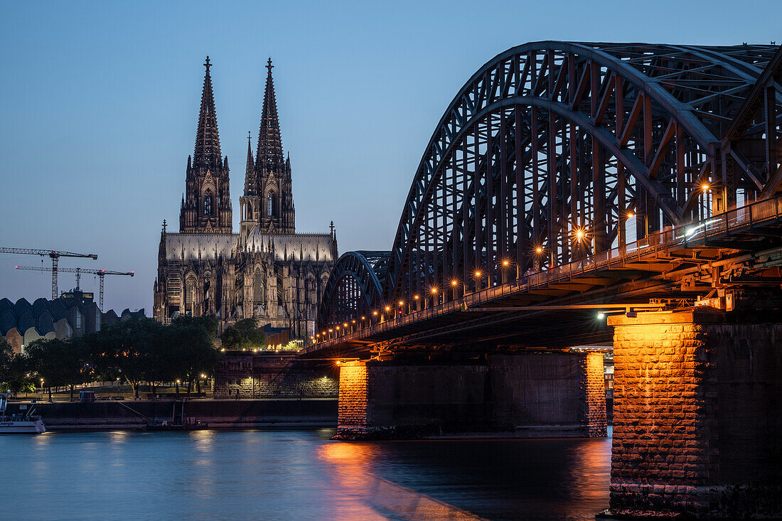 Cologne Cathedral, UNESCO World Heritage Site, and Hohenzollern Bridge at dusk, Cologne, North Rhine-Westphalia, Germany, Europe\n