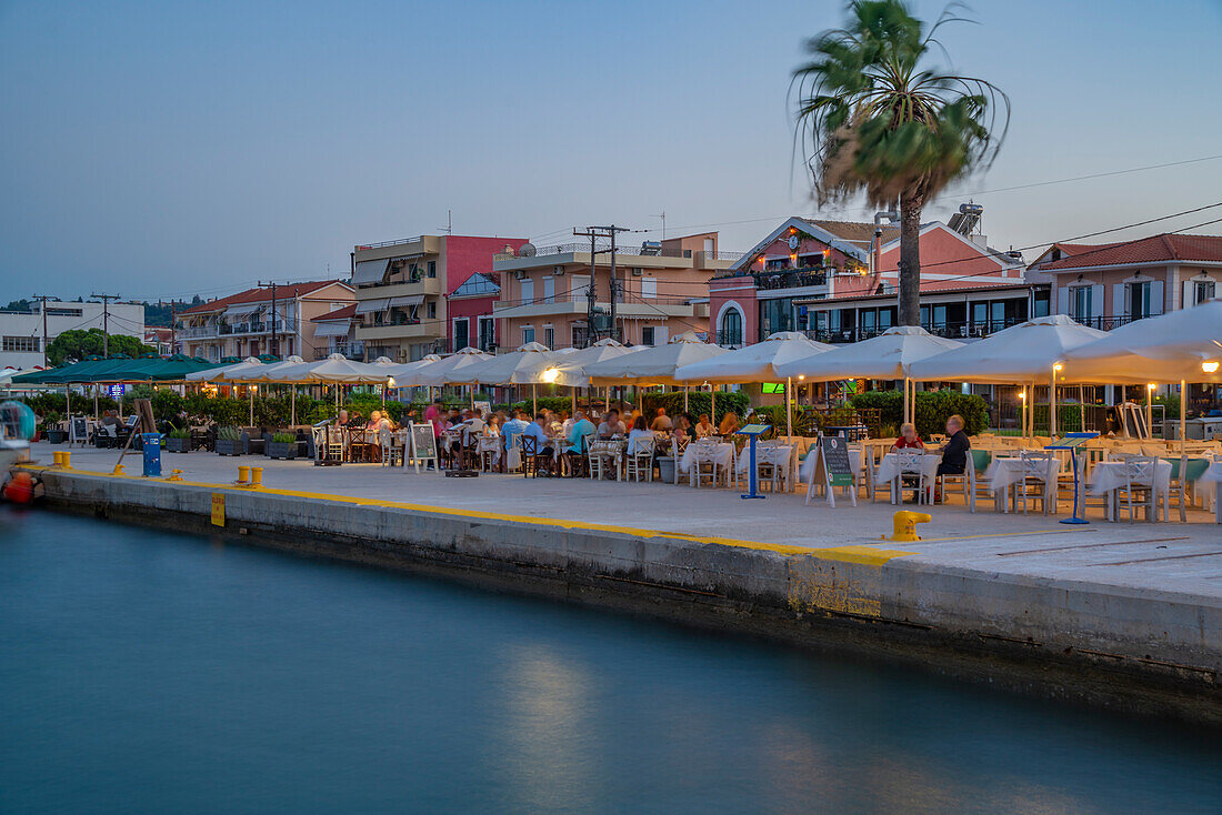 Blick auf Cafe und Restaurant am Hafen in der Abenddämmerung, Lixouri, Kefalonia, Ionische Inseln, Griechische Inseln, Griechenland, Europa
